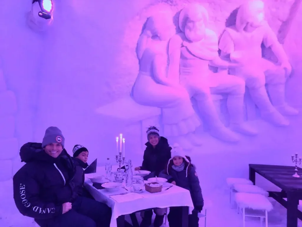família sentada em uma mesa dentro de uma caverna de gelo